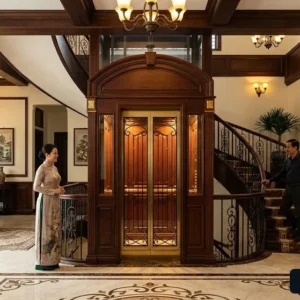 Thang máy cabin gỗ phong cách Indochine đồng bộ hoàn hảo với không gian nội thất gỗ.